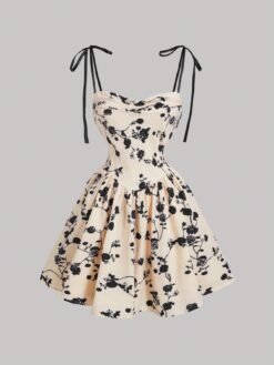 Vestido corto con estampado floral en tonos neutros y negros, con tirantes de lazo, ideal para ocasiones especiales.