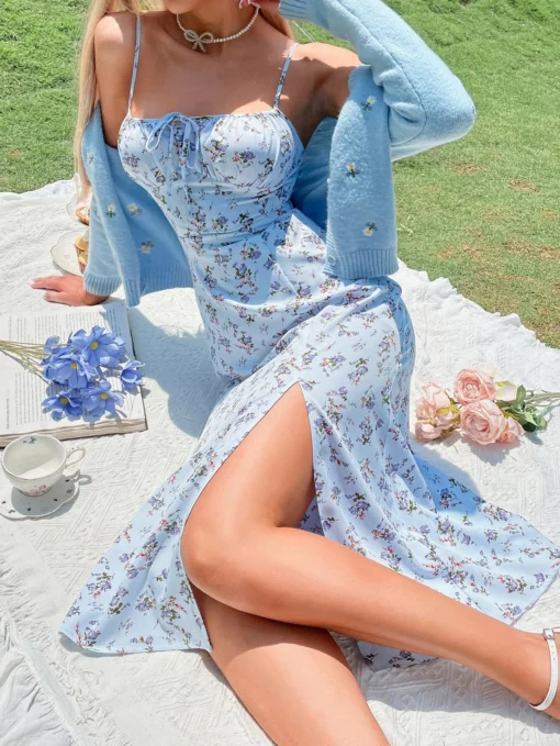 Mujer posando con un vestido azul floral, resaltando la abertura alta.