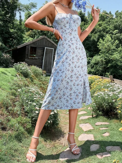 Mujer vistiendo un vestido midi azul floral con tirantes finos y escote fruncido.