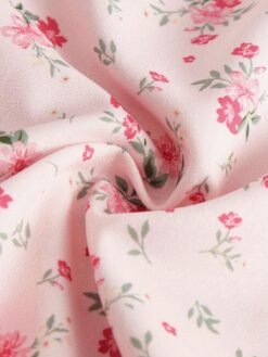 Primer plano del estampado floral de margaritas en el vestido midi rosa pálido.