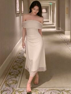 Mujer caminando con vestido midi beis elegante en un pasillo.