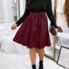 Mujer con vestido burdeos a línea y cinturón, estilo casual.