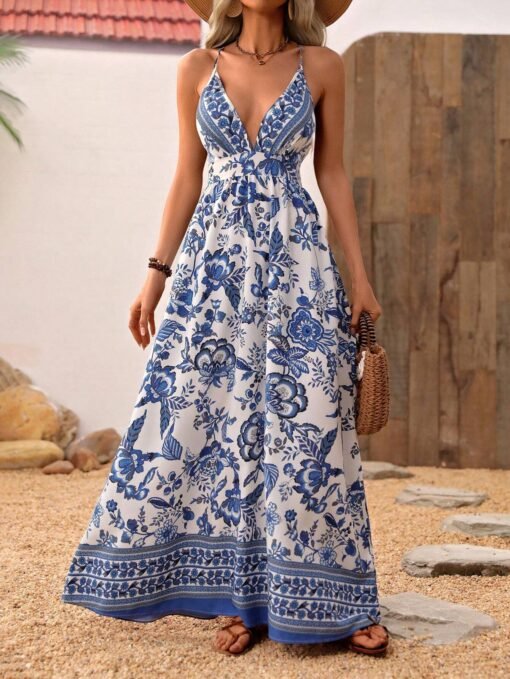 Modelo usando vestido largo bohemio azul y blanco con estampado floral y tirantes finos cruzados.