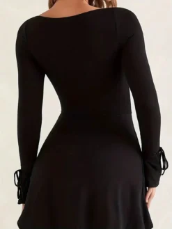 Vista trasera del vestido negro con escote cuadrado y corte mini, con mangas de campana.