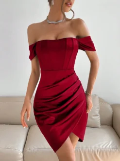 Mujer con vestido rojo ajustado de satén con hombros descubiertos, mostrando un look elegante.