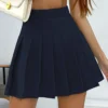 Falda plisada azul con cremallera lateral y cintura alta.