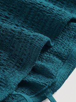 Detalle del tejido texturizado del vestido verde casual.