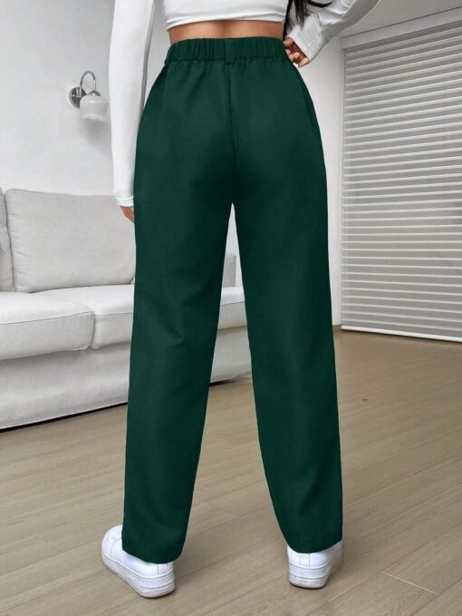 Pantalón verde con detalles de botón y cremallera, visto desde atrás.