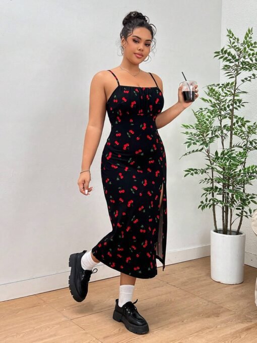 Modelo con el vestido midi de tirantes finos y estampado de cerezas, sujetando una bebida.