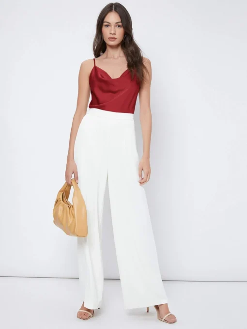 Combinación de la blusa burdeos con pantalones blancos para un estilo elegante y moderno.