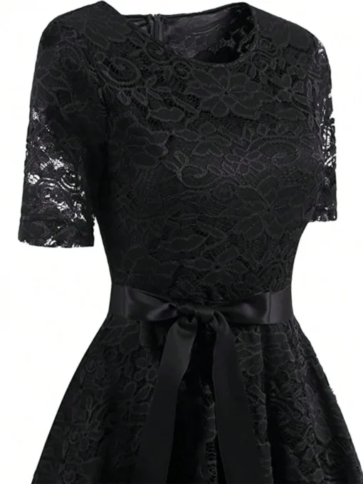 Detalle del cinturón del vestido vintage negro en primer plano.