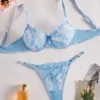 Conjunto de lencería azul con bordado floral y diseño transparente.
