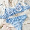 Conjunto de lencería azul con bordado floral y transparencias.