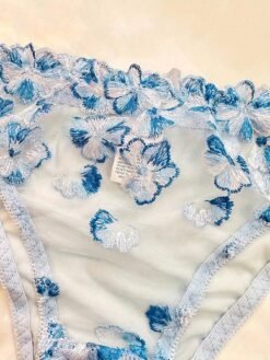 Detalle del bordado floral en el sujetador azul transparente.