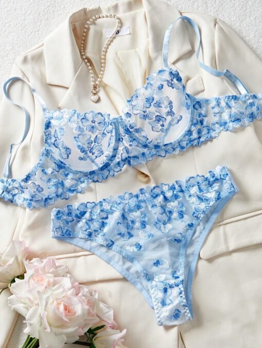 Conjunto de lencería azul con bordado floral y transparencias.