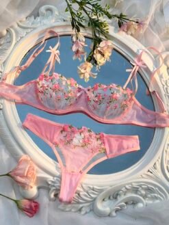 Conjunto de ropa interior rosa con bordado floral, vista frontal.