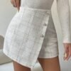 Falda pantalón blanca de tweed con diseño envolvente.