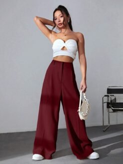 Modelo usando el pantalón marrón con un crop top blanco y zapatillas.