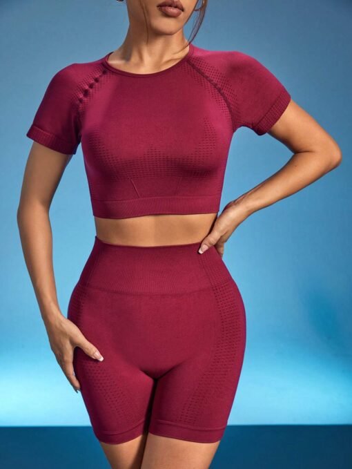 Modelo luciendo conjunto deportivo burdeos para entrenamiento de yoga.
