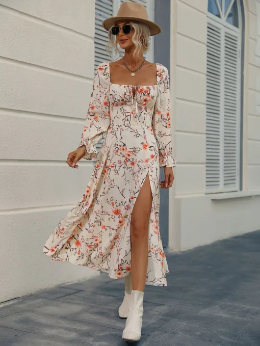 Mujer usando un vestido largo floral con abertura, mangas largas y escote cuadrado, combinándolo con botas blancas.