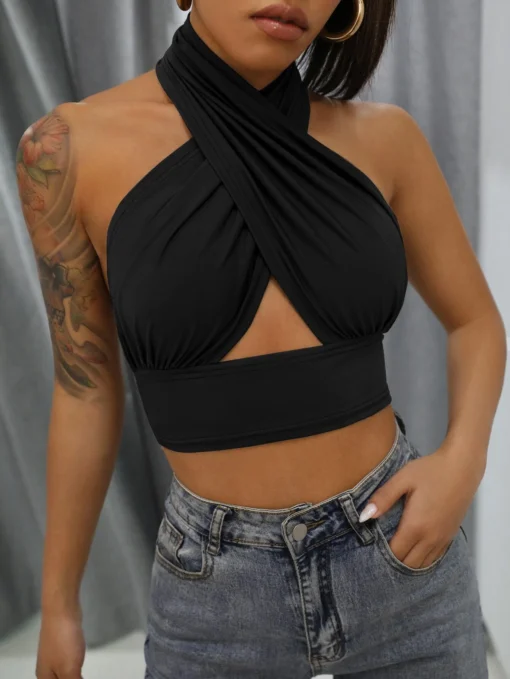 Modelo luciendo un top negro halter cruzado con jeans
