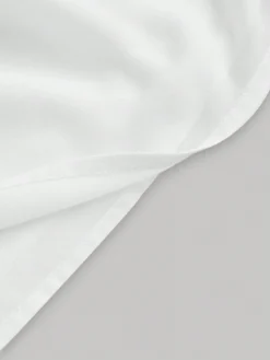 Detalle de la tela del vestido blanco corto de tirantes finos.