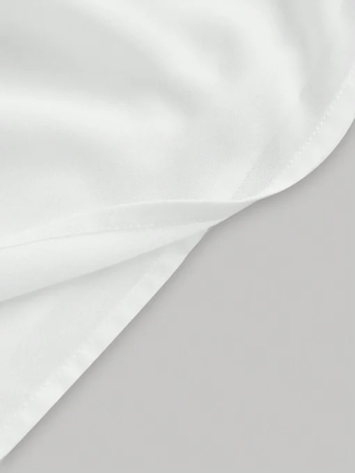 Detalle de la tela del vestido blanco corto de tirantes finos.