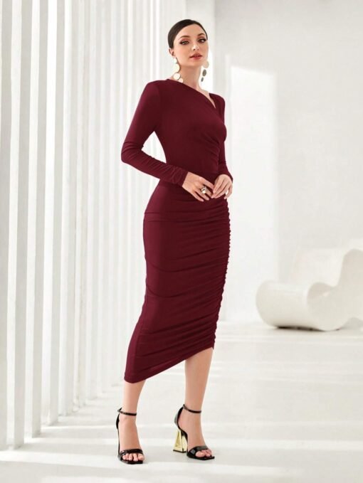Modelo luciendo vestido largo burdeos elegante en ambiente minimalista.