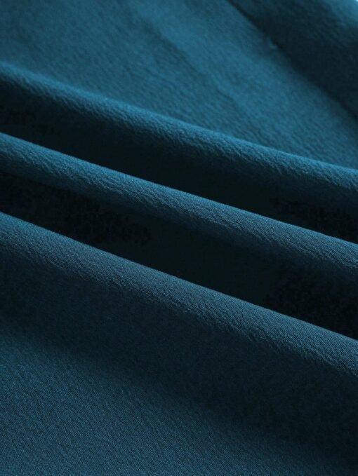Detalle del tejido del mono largo de tirantes agua verde azul, resaltando su textura y calidad.