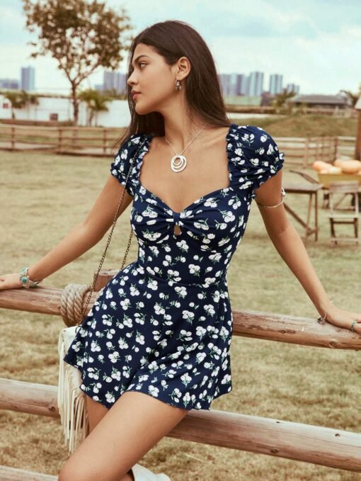 Mujer con vestido bohemio azul con estampado floral, en un ambiente campestre.