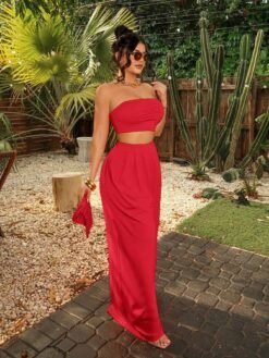 Mujer posando con conjunto rojo bohemio sin tirantes en un ambiente tropical.