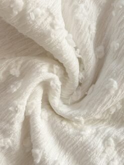 Detalle del tejido texturizado del conjunto bohemio blanco