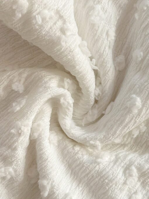 Detalle del tejido texturizado del conjunto bohemio blanco