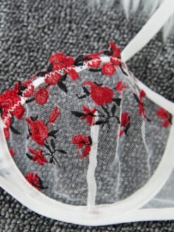 Detalle del sujetador con aro y bordado floral rojo del conjunto lencería blanco.