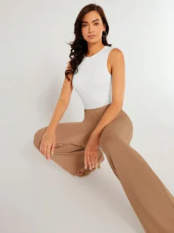 Body blanco sin mangas combinado con pantalón beige.