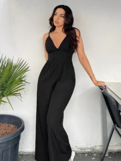 Modelo usando el mono negro casual de tirantes con encaje en el escote.
