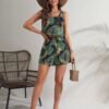 Modelo usando conjunto tropical multicolor de 2 piezas con sombrero y sandalias.