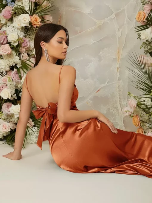 Vista lateral del vestido óxido marrón maxi con caída fluida y corte A línea