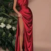 Modelo luciendo el vestido elegante rojo con abertura alta y escote asimétrico.