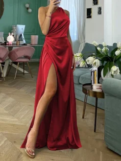 Modelo en interiores posando con el vestido elegante rojo con abertura alta.