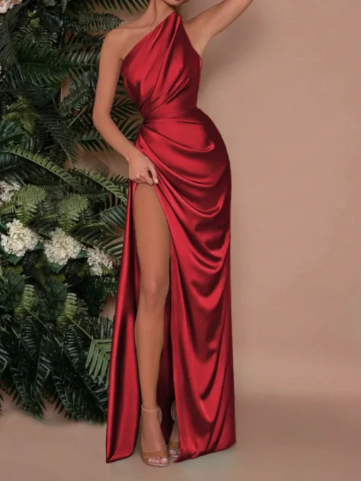 Modelo luciendo el vestido elegante rojo con abertura alta y escote asimétrico.