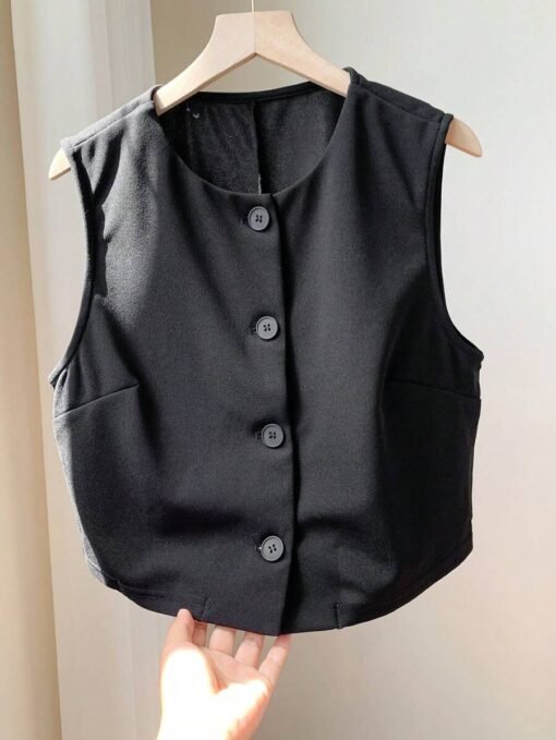 Vista plana del top crop negro casual colgado en perchero.