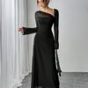 Vista frontal del vestido elegante negro asimétrico con mangas largas transparentes.