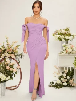 Modelo usando el vestido sirena lila en un entorno floral elegante