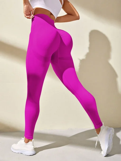 Vista trasera de los leggings deportivos fucsia mostrando el efecto moldeador.