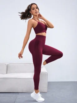 Vista lateral del set deportivo rosa mostrando top con tirantes y leggings de cintura alta.