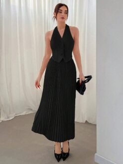 Conjunto negro halter con top tipo chaleco y falda plisada visto desde el frente