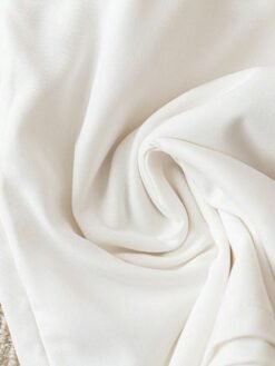 Detalle del lazo decorativo en el short blanco del set casual.