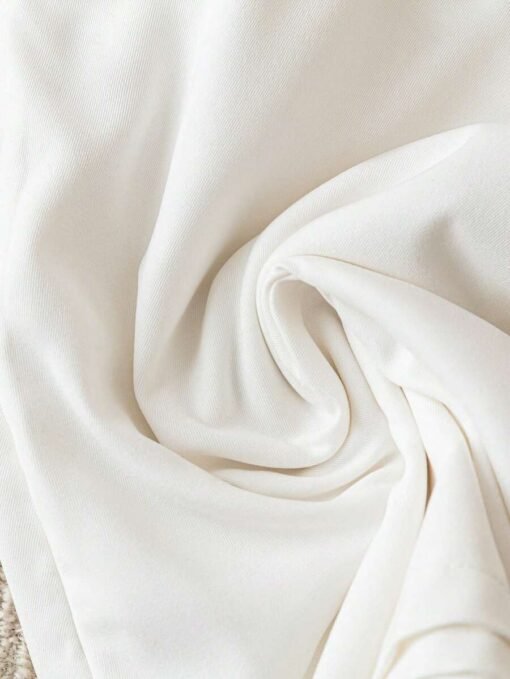 Detalle del lazo decorativo en el short blanco del set casual.