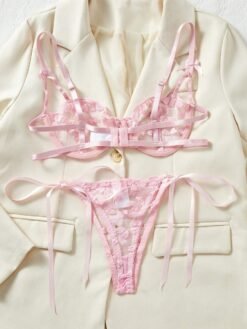 Conjunto sexy rosa con transparencias, detalle de tanga sobre fondo claro.